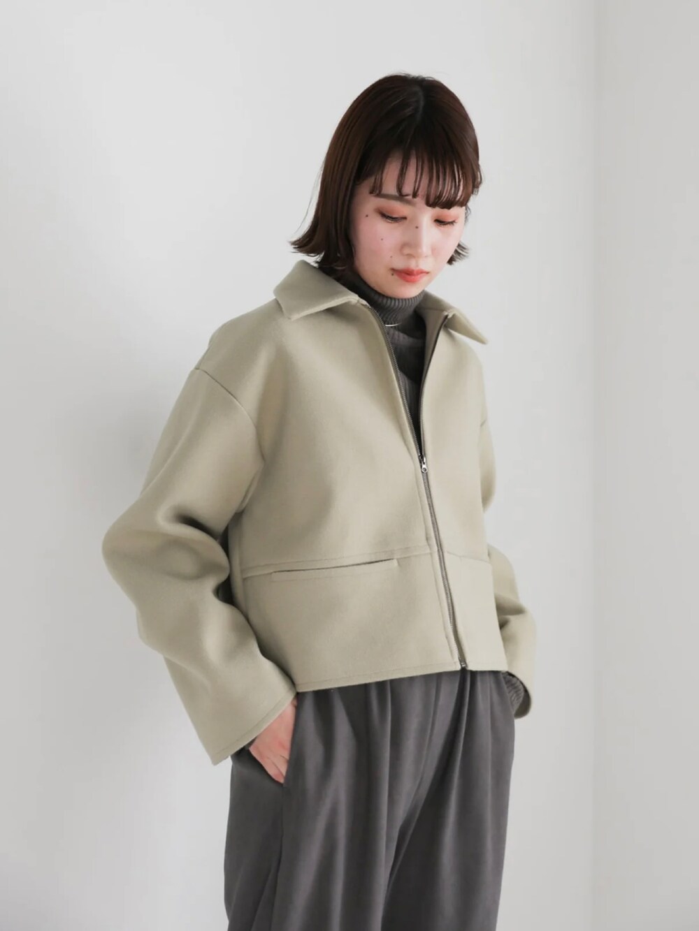 グリーン系のブルゾン、ブラック系のその他パンツ、ブラック系のブーツを着用したレディースの冬コーディネートの5枚目の写真