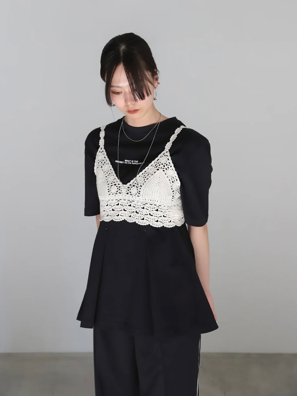 ブラック系のスラックス、ブラック系のサンダル、ブラック系のハンドバッグを着用したレディースの春コーディネートの3枚目の写真