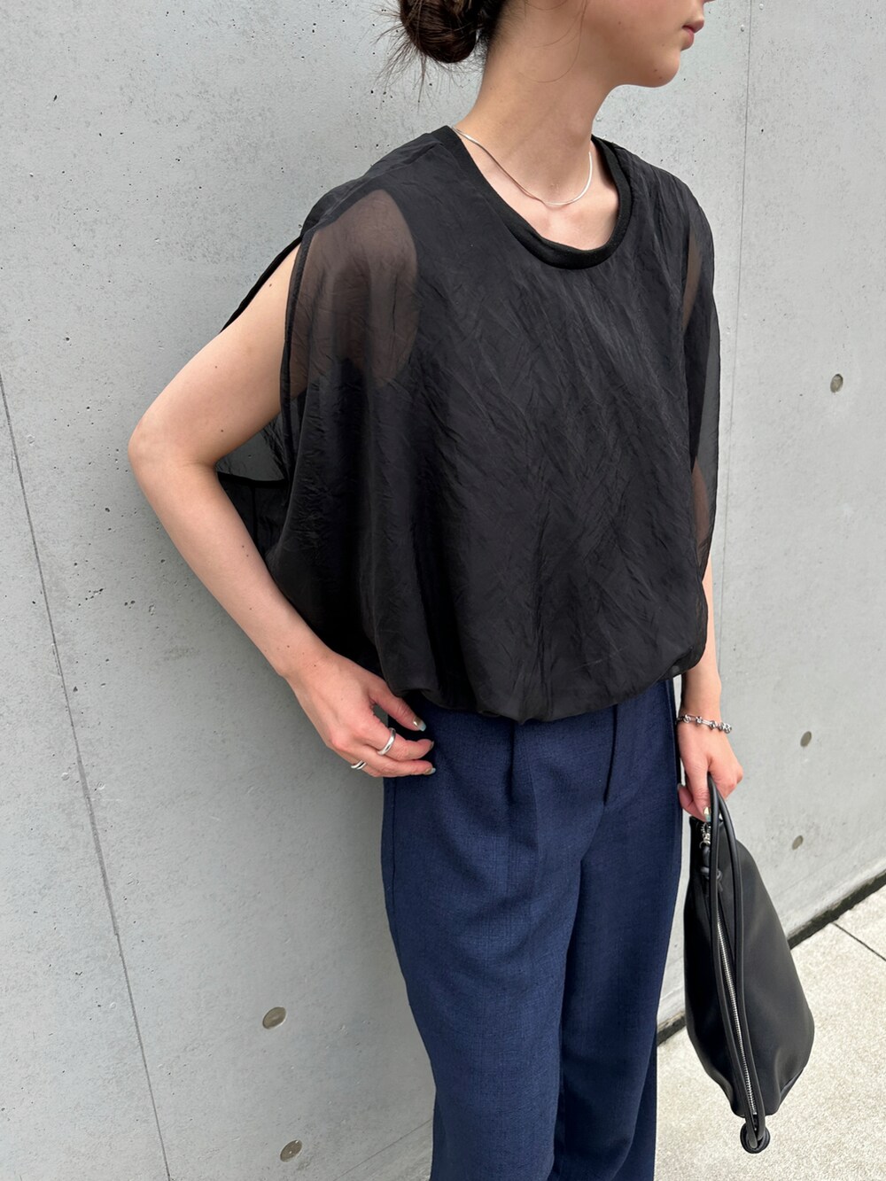 ブルー系のスラックス、ブラック系のショルダーバッグ、ブラック系のサンダルを着用したレディースの夏コーディネートの3枚目の写真