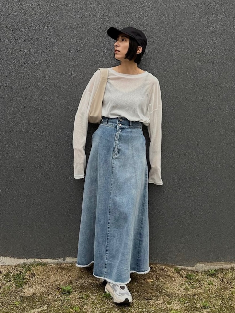 ホワイト系のTシャツ/カットソー、ブラック系のテーラードジャケット、ブルー系のデニムスカートを着用したレディースの冬コーディネートの3枚目の写真