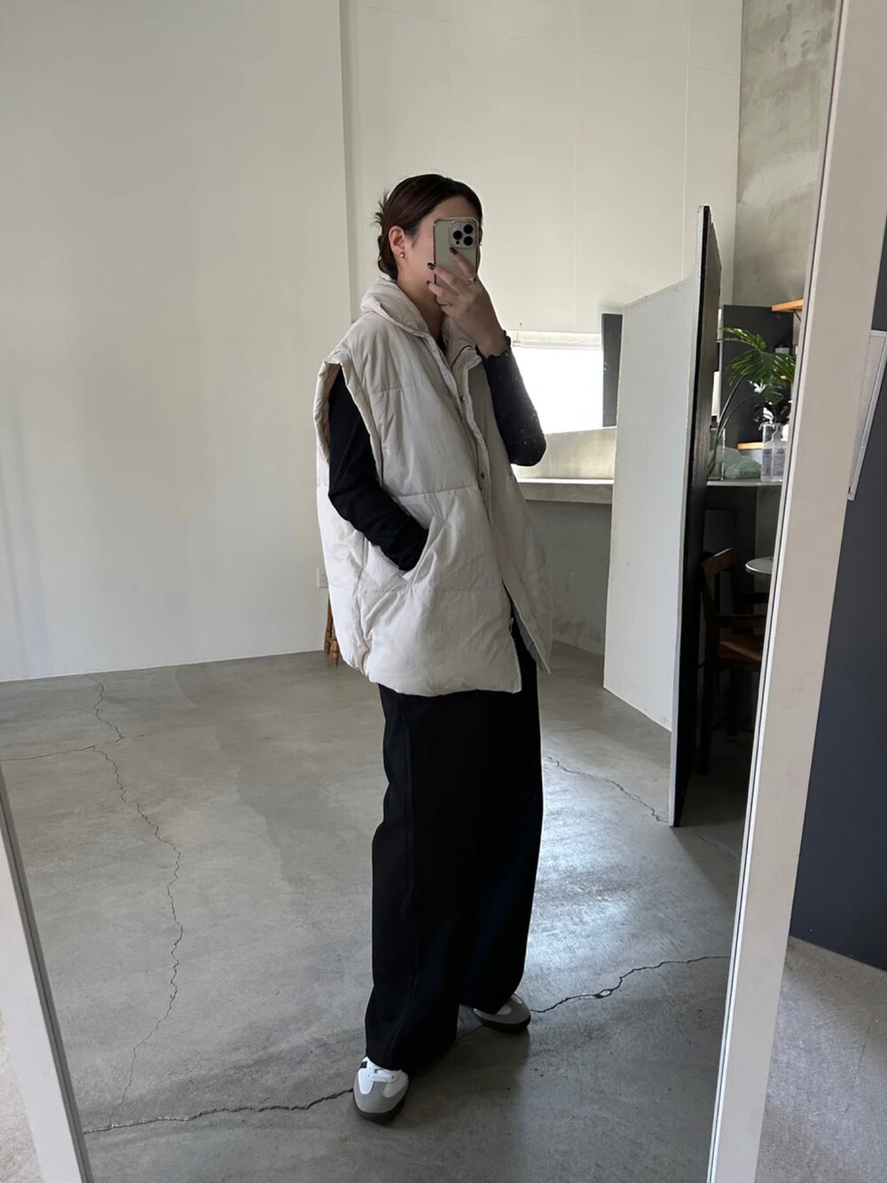 ホワイト系のダウンベストを着用したレディースの冬コーディネートの3枚目の写真