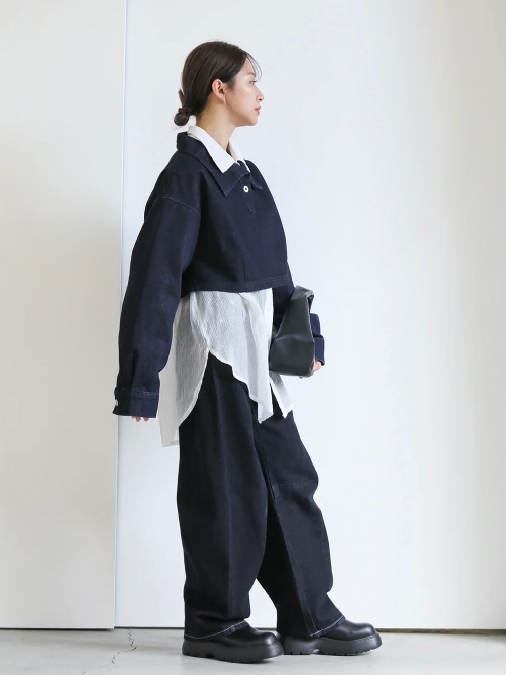 ブルー系のその他トップス、ブラック系のショルダーバッグ、ブラック系のブーツを着用したレディースの冬コーディネートの2枚目の写真