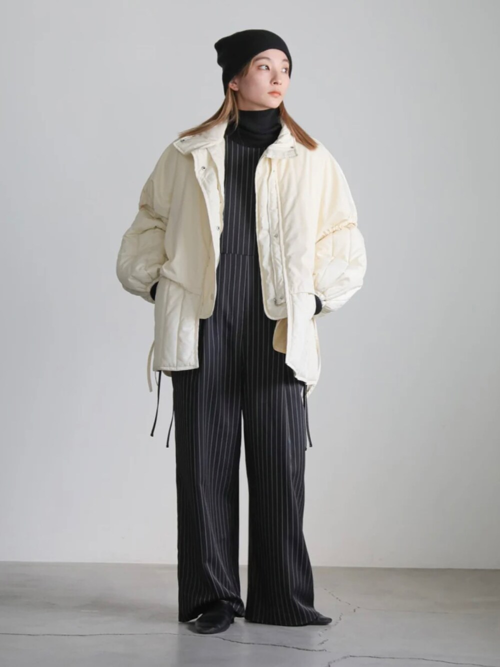 ホワイト系のダウンジャケット/コート、ブラック系のニットキャップ/ビーニーを着用したレディースの冬コーディネートの5枚目の写真