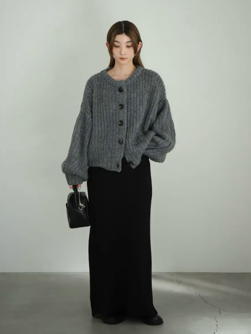 グレー系のカーディガン/ボレロ、ブラック系のスカート、ブラック系のスリッポンを着用したレディースの夏コーディネートの3枚目の写真