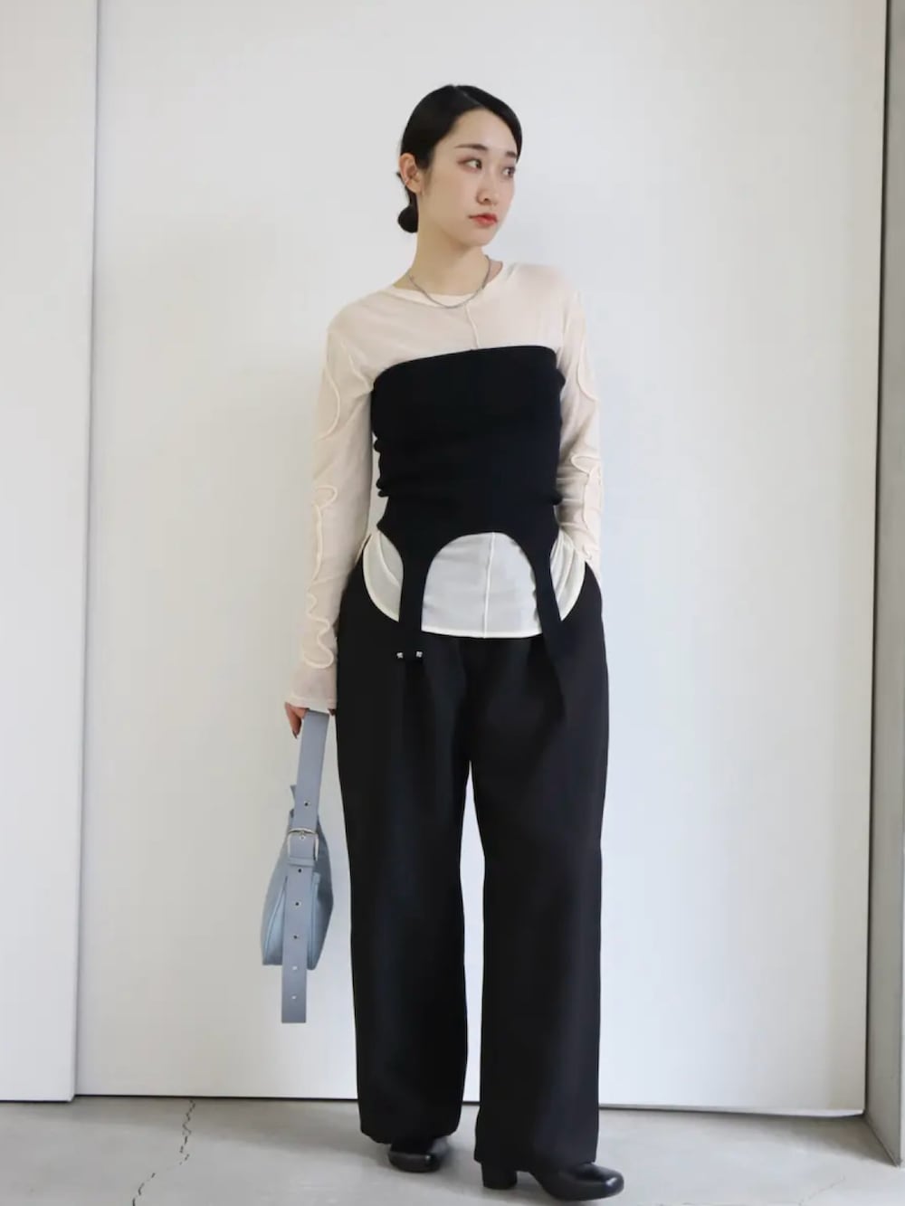 ホワイト系のTシャツ/カットソー、ブラック系のベスト、ブラック系のスラックスを着用したレディースの冬コーディネートの2枚目の写真