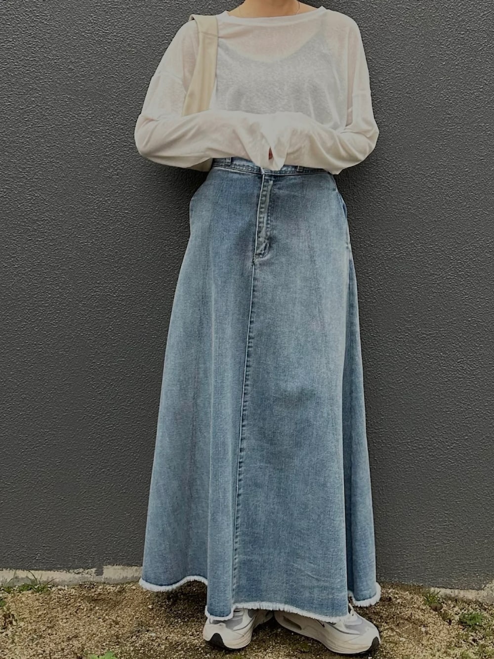 ホワイト系のTシャツ/カットソー、ブラック系のテーラードジャケット、ブルー系のデニムスカートを着用したレディースの冬コーディネートの4枚目の写真