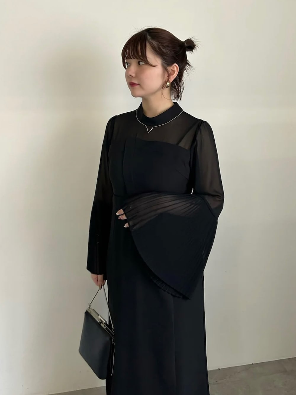 グレー系のワンピース、ブラック系のショルダーバッグ、ブラック系のパンプスを着用したレディースの春コーディネートの5枚目の写真