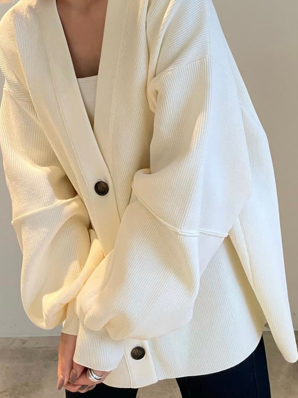 ホワイト系のカーディガン/ボレロ、ホワイト系のキャミソール、ブルー系のデニムパンツを着用したレディースの夏コーディネートの2枚目の写真