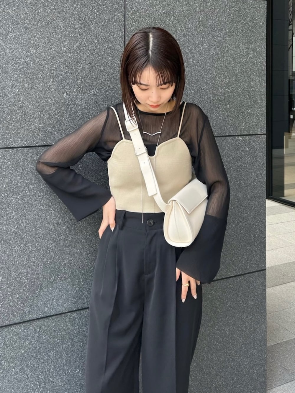 ブラック系のシャツ/ブラウス、ベージュ系のベスト、ホワイト系のショルダーバッグを着用したレディースの春コーディネートの4枚目の写真