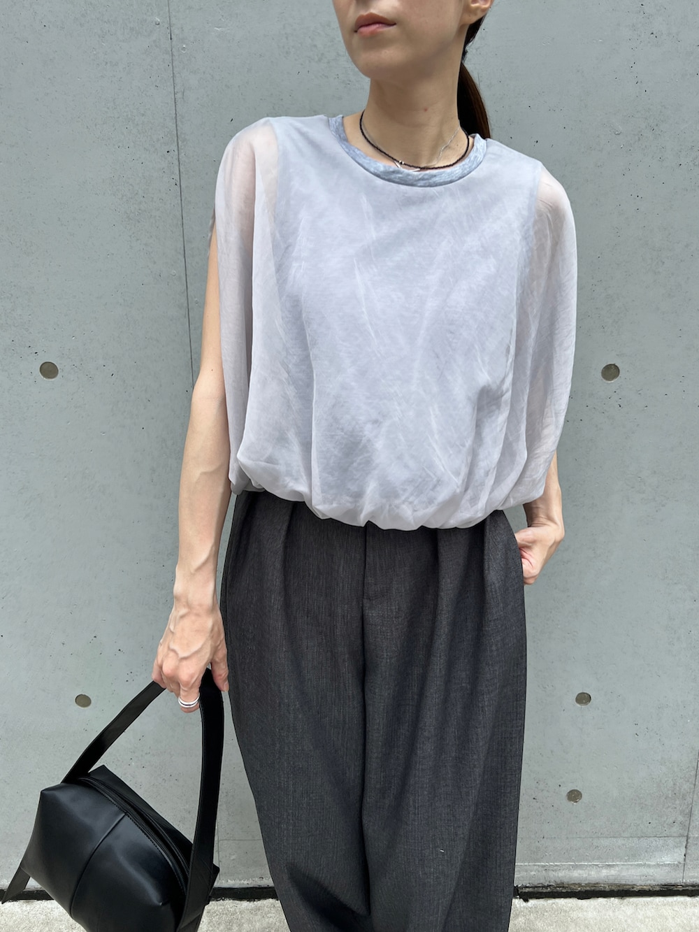 グレー系のシャツ/ブラウス、ブラック系のショルダーバッグ、グレー系のスラックスを着用したレディースの夏コーディネートの3枚目の写真