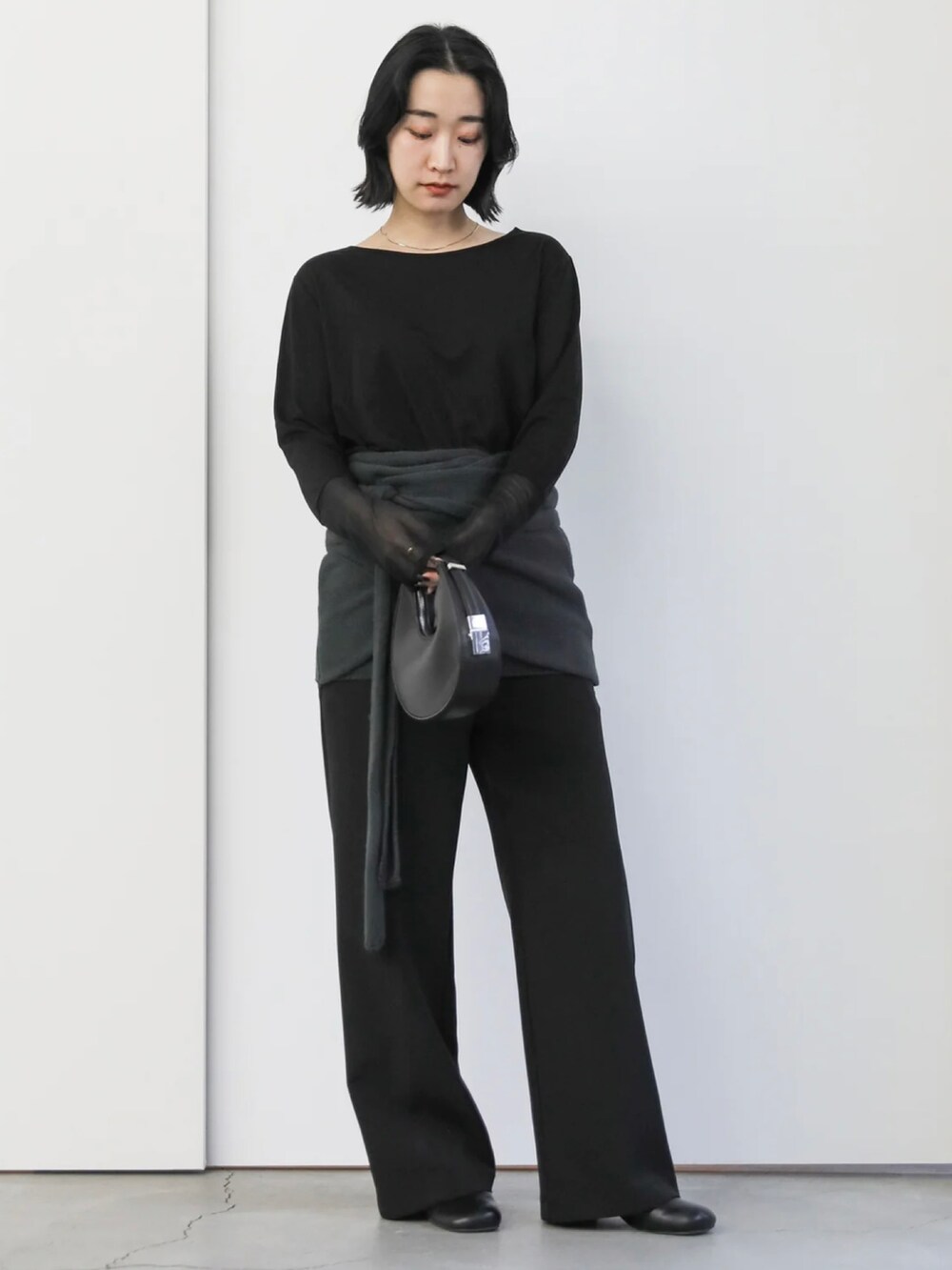 ブラック系のTシャツ/カットソー、ブラック系のハンドバッグ、ブラック系のサンダルを着用したレディースの冬コーディネートの3枚目の写真