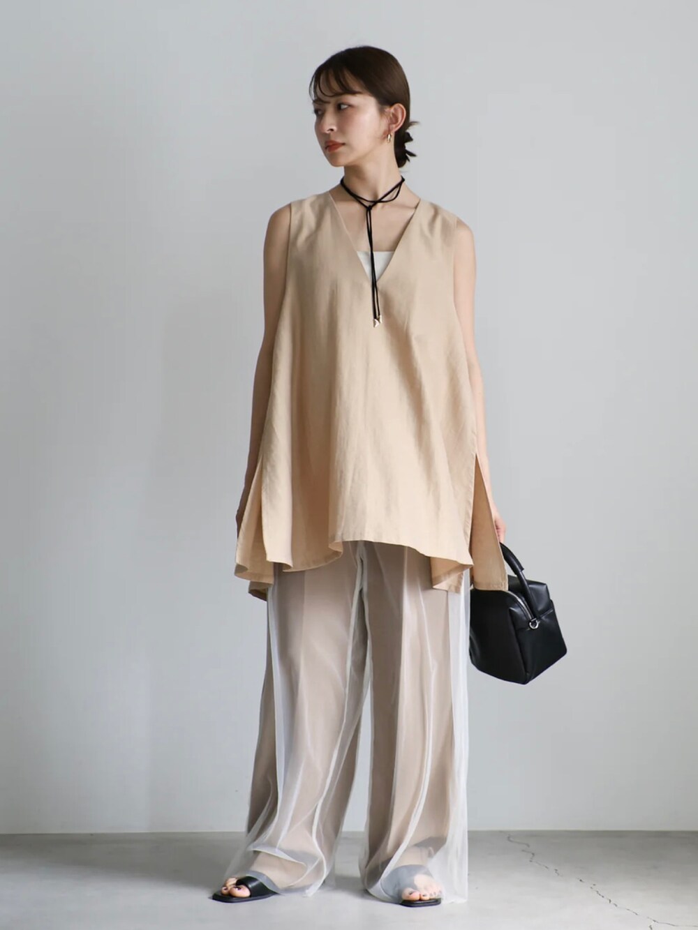 ベージュ系のベスト、ホワイト系のキャミソール、ホワイト系のその他パンツを着用したレディースの夏コーディネートの4枚目の写真