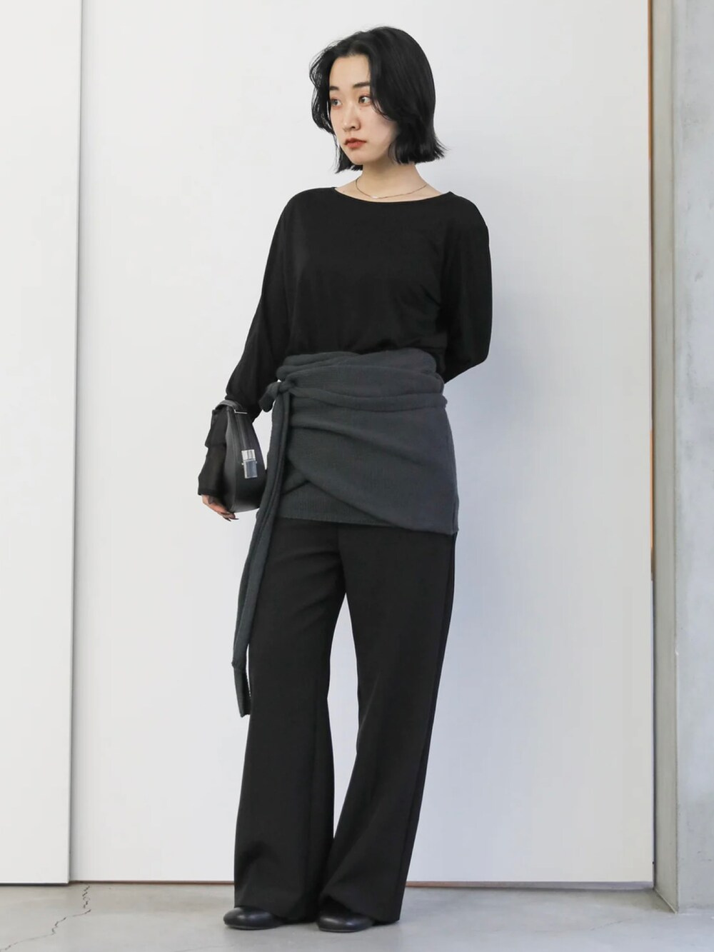 ブラック系のTシャツ/カットソー、ブラック系のハンドバッグ、ブラック系のサンダルを着用したレディースの冬コーディネートの2枚目の写真