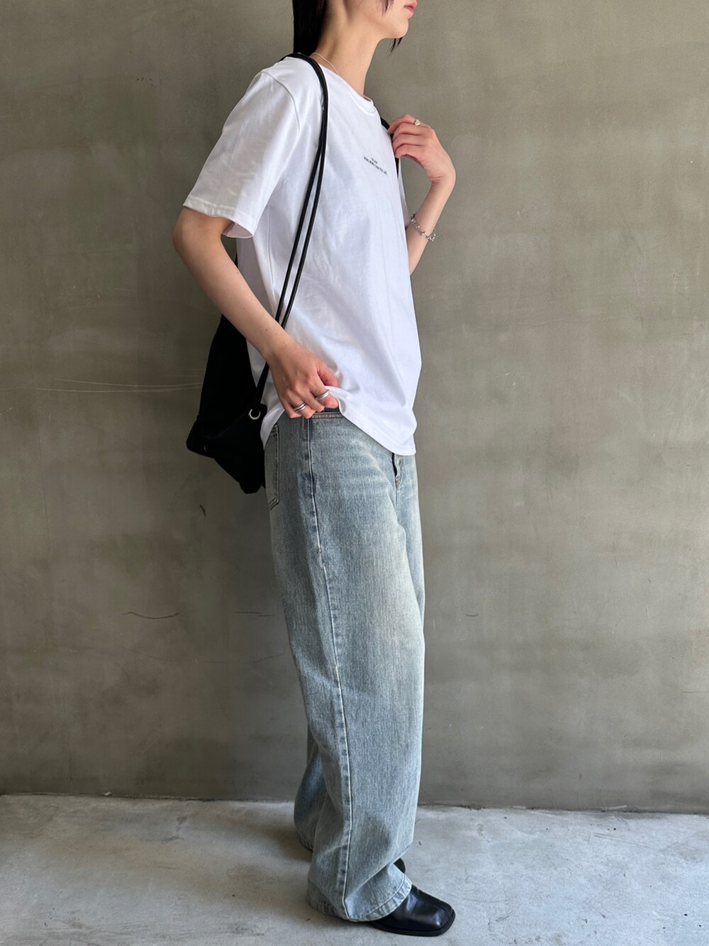 ホワイト系のTシャツ/カットソー、ブルー系のデニムパンツ、ブラック系のバックパック/リュックを着用したレディースの春コーディネートの2枚目の写真