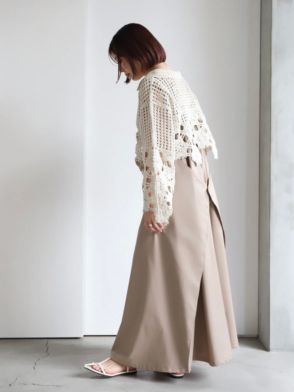 ホワイト系のニット/セーター、ベージュ系のジャンパースカート、ホワイト系のキャミソールを着用したレディースの春コーディネートの3枚目の写真