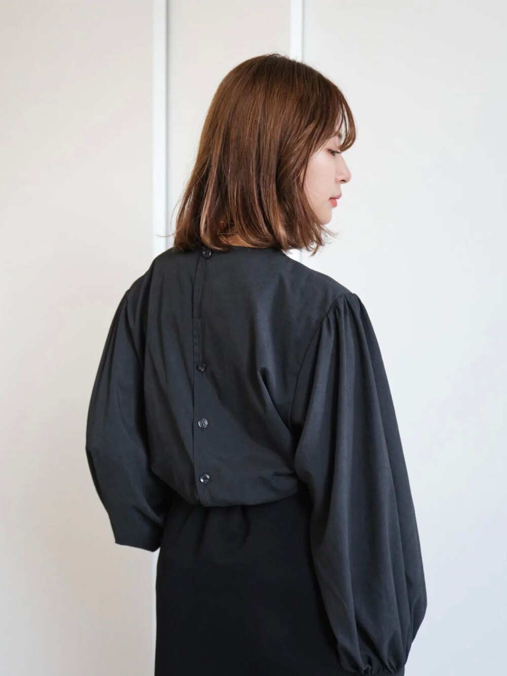 ブラック系のハンドバッグ、ブラック系のシャツ/ブラウス、ブラック系のスカートを着用したレディースの冬コーディネートの5枚目の写真