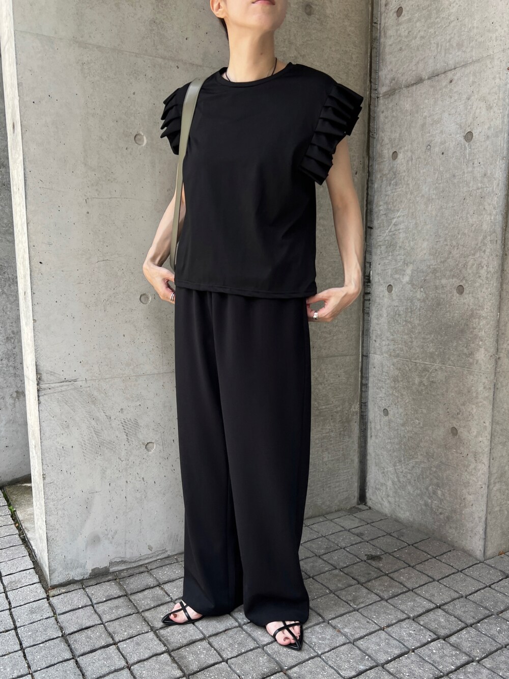 ブラック系のTシャツ/カットソー、グリーン系のショルダーバッグ、ブラック系のその他パンツを着用したレディースの夏コーディネートの2枚目の写真