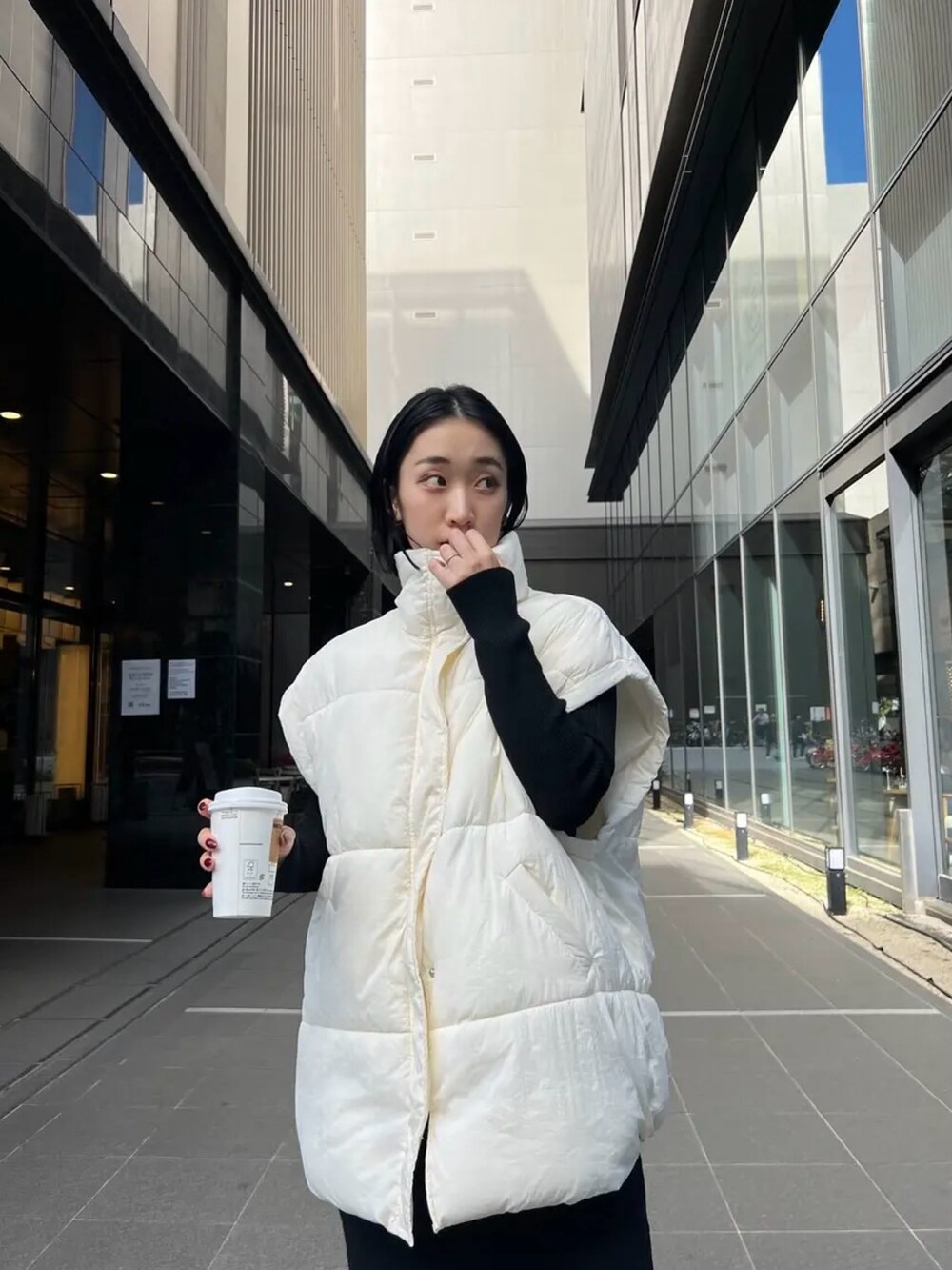 ホワイト系のダウンベストを着用したレディースの秋コーディネートの3枚目の写真