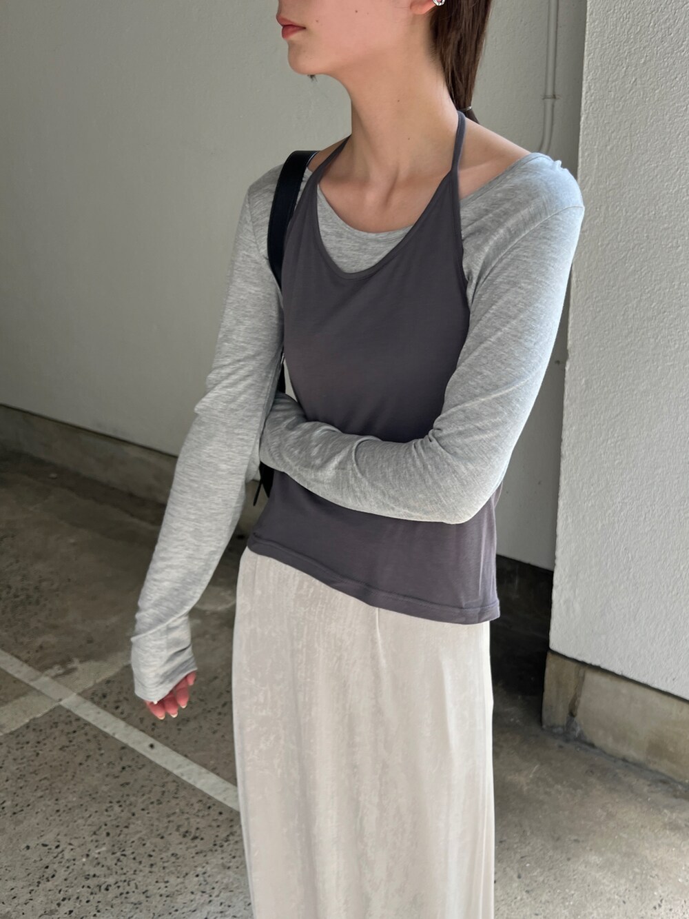 グレー系のTシャツ/カットソー、ホワイト系のスカート、ブラック系のショルダーバッグを着用したレディースの秋コーディネートの3枚目の写真