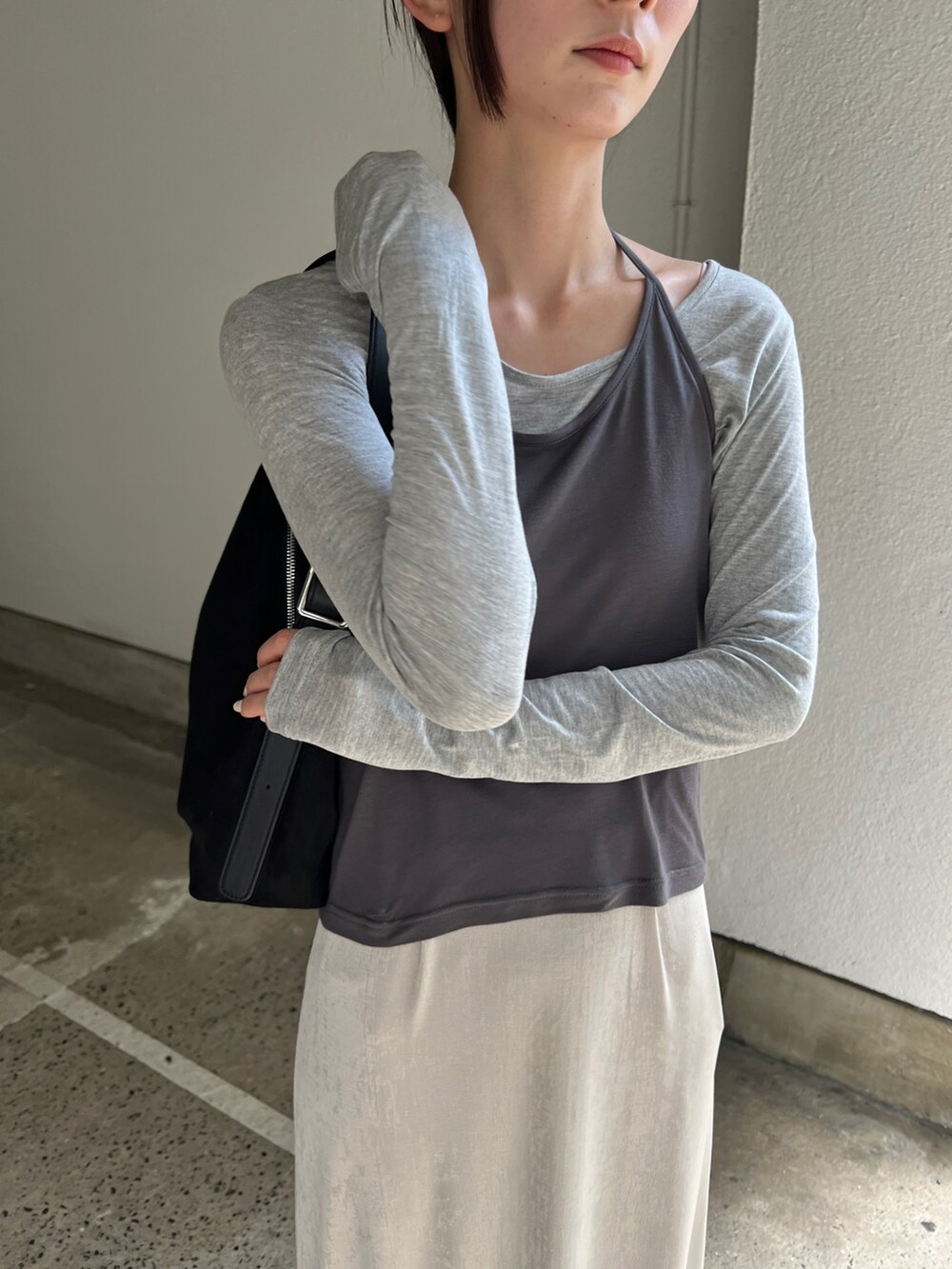 グレー系のTシャツ/カットソー、ホワイト系のスカート、ブラック系のショルダーバッグを着用したレディースの秋コーディネートの4枚目の写真