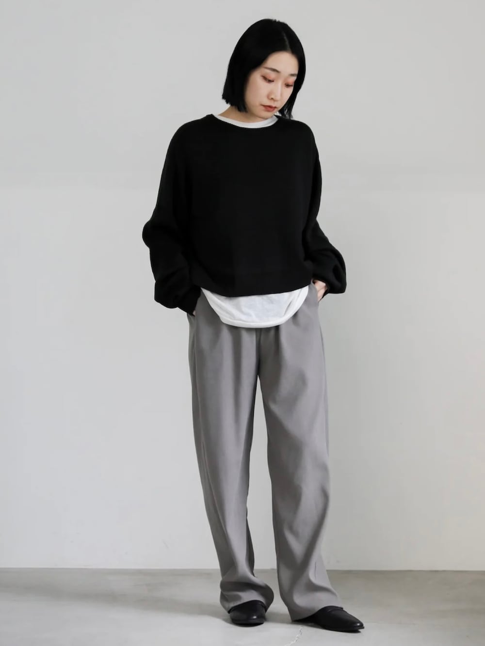 ブラック系のニット/セーター、グレー系のその他パンツを着用したレディースの冬コーディネートの2枚目の写真