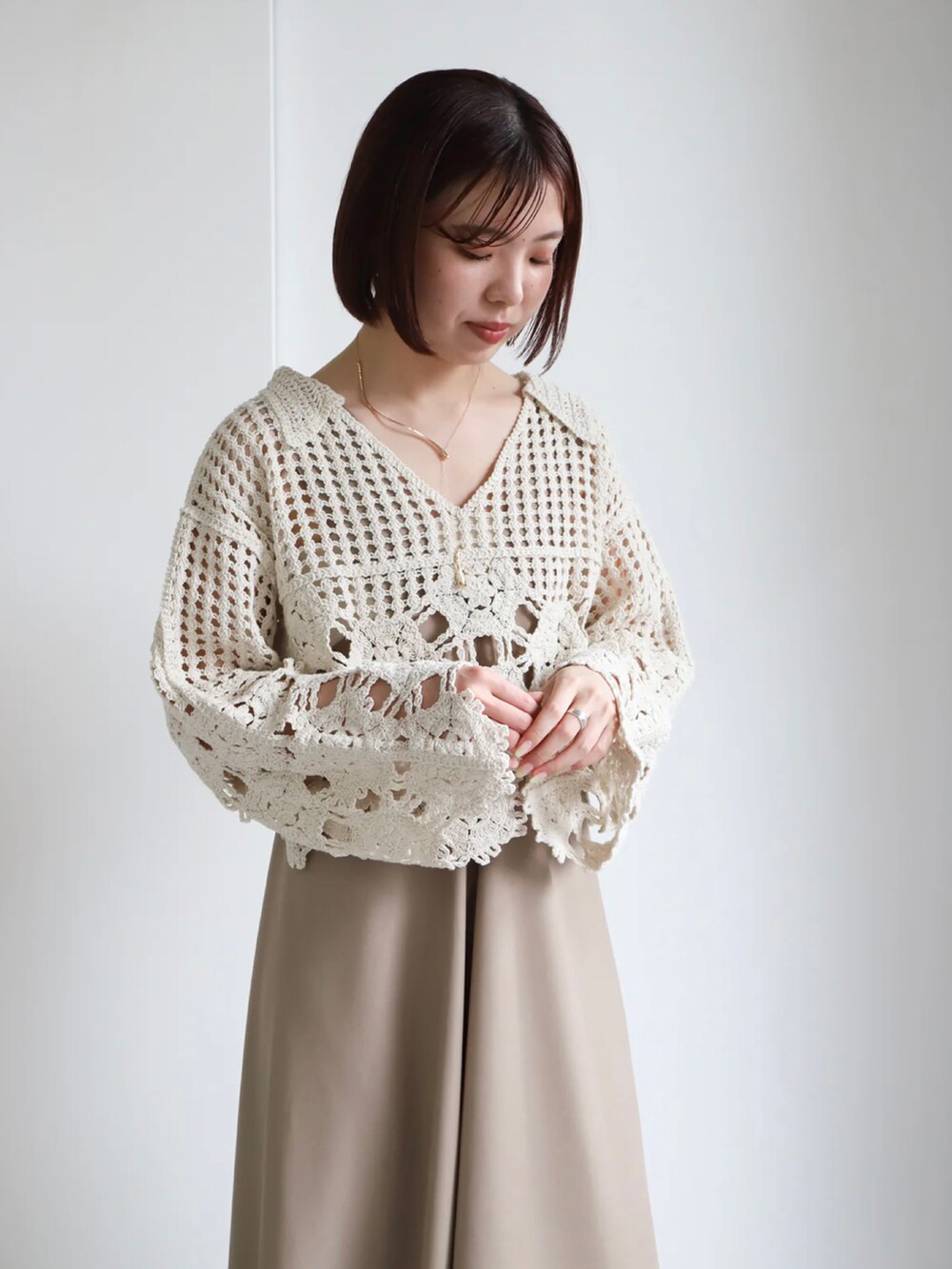 ホワイト系のニット/セーター、ベージュ系のジャンパースカート、ホワイト系のキャミソールを着用したレディースの春コーディネートの5枚目の写真