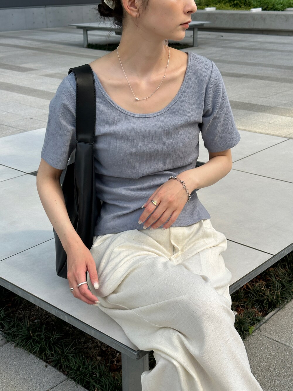 ブルー系のTシャツ/カットソー、ホワイト系のスラックス、ブラック系のトートバッグを着用したレディースの春コーディネートの5枚目の写真