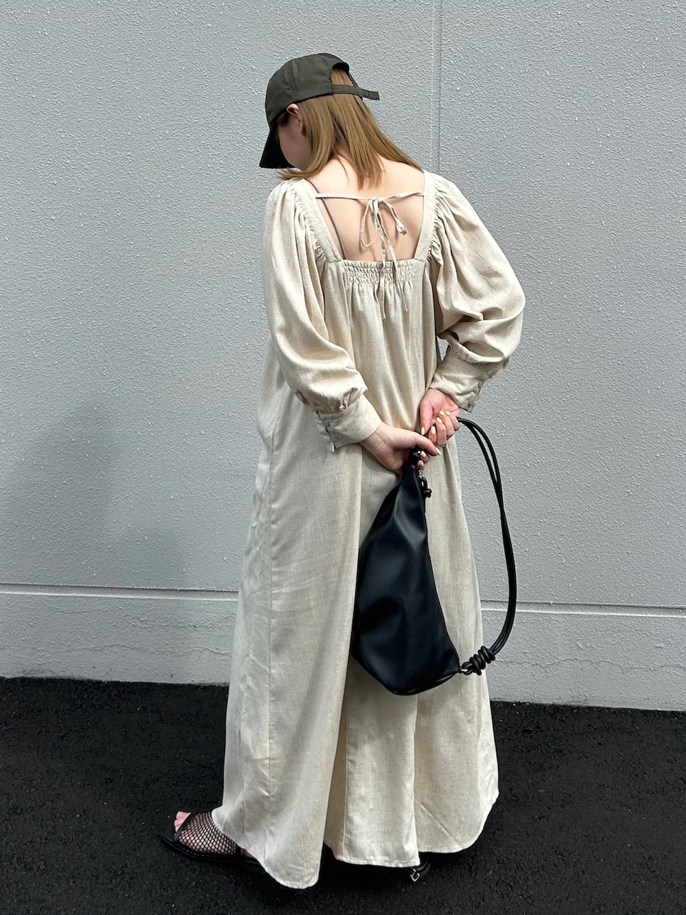 ベージュ系のワンピース、ブラック系のショルダーバッグ、グリーン系のキャップを着用したレディースの夏コーディネートの5枚目の写真