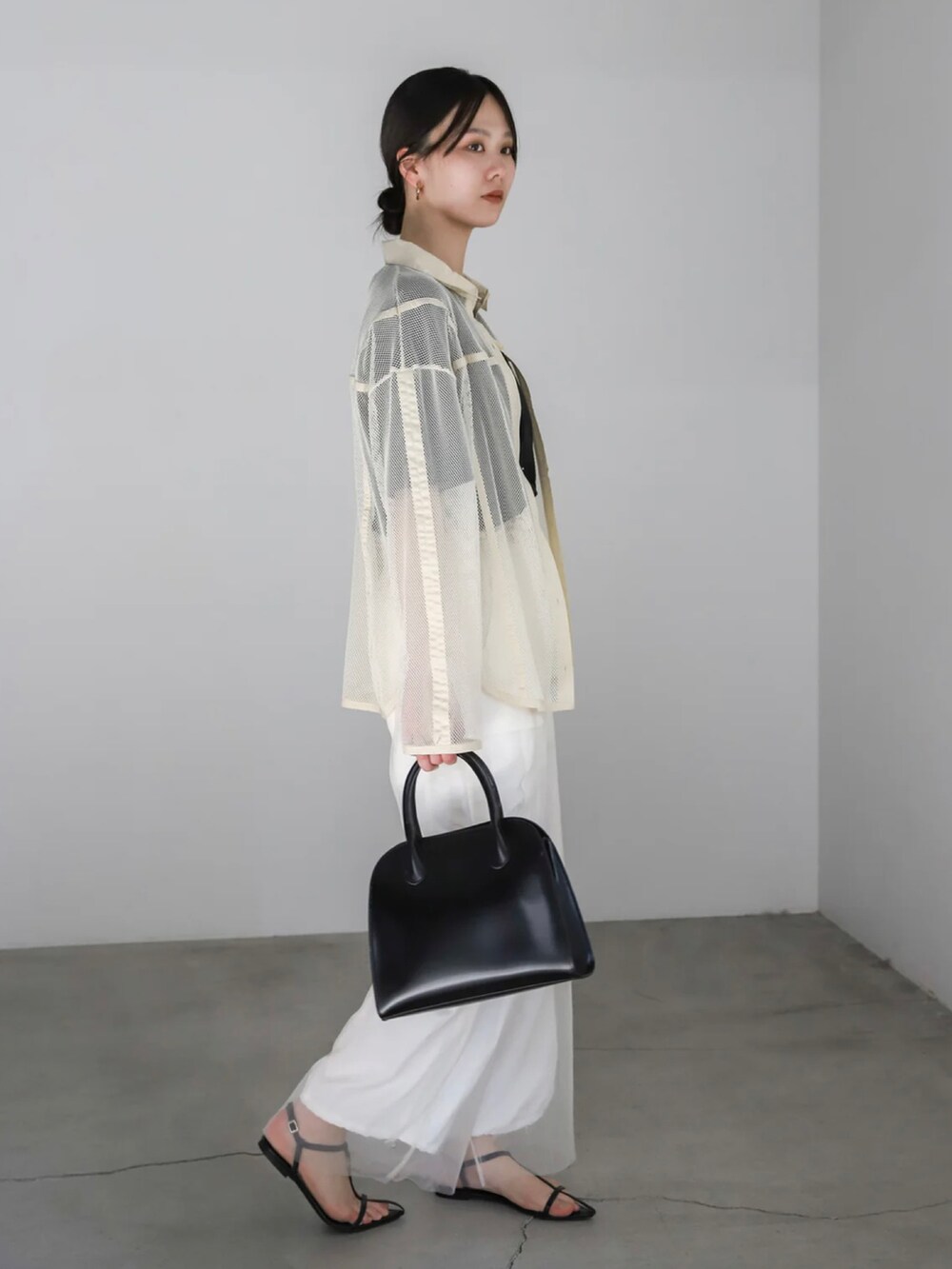 ホワイト系のシャツ/ブラウス、ホワイト系のカーゴパンツ、ブラック系のボストンバッグを着用したレディースの春コーディネートの2枚目の写真