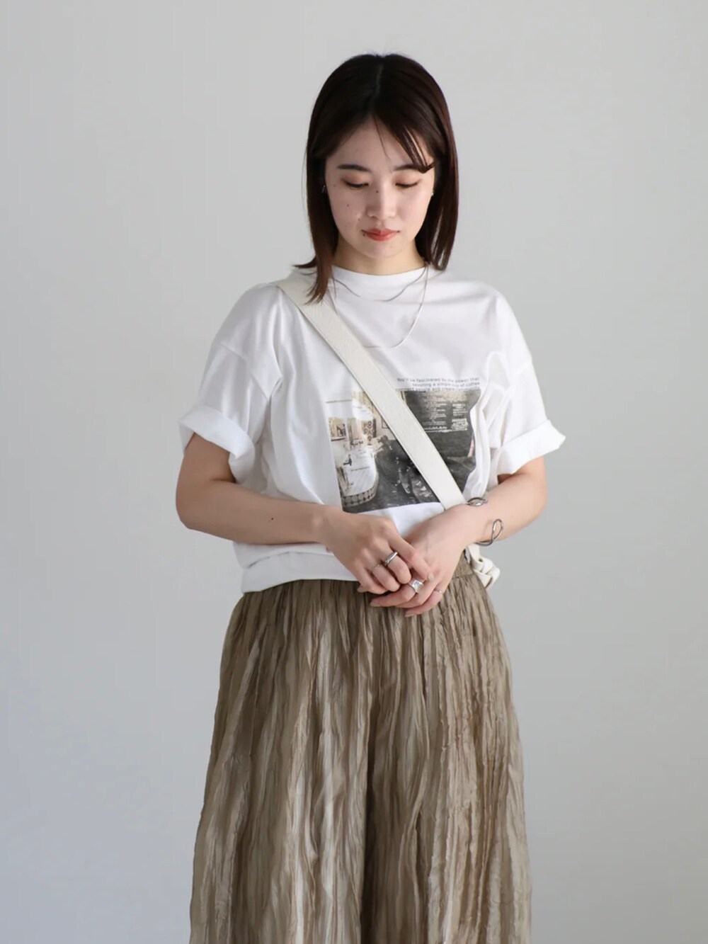 ホワイト系のTシャツ/カットソー、ホワイト系のスラックス、ブラウン系のワンピースを着用したレディースの夏コーディネートの5枚目の写真