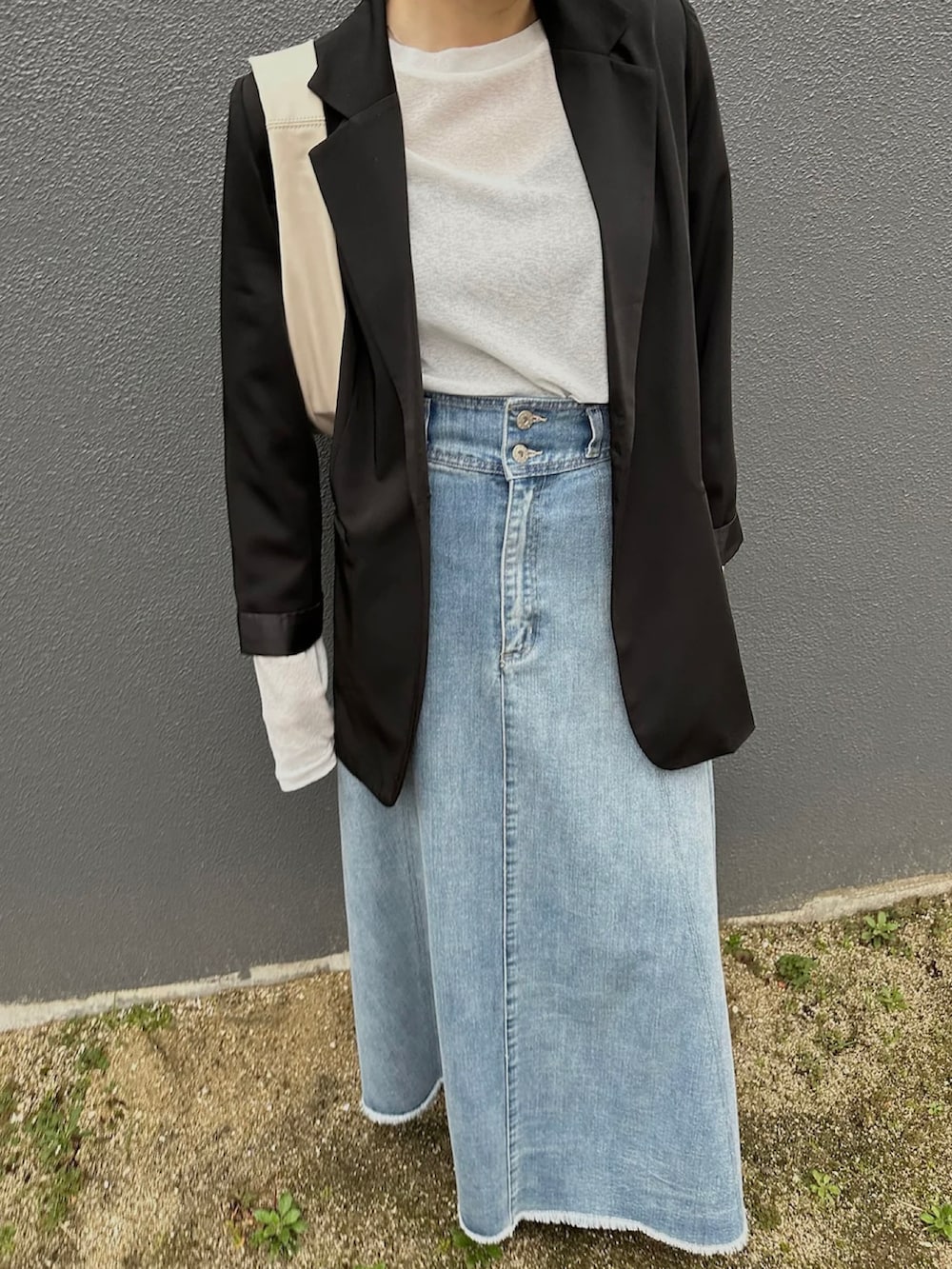 ホワイト系のTシャツ/カットソー、ブラック系のテーラードジャケット、ブルー系のデニムスカートを着用したレディースの冬コーディネートの2枚目の写真