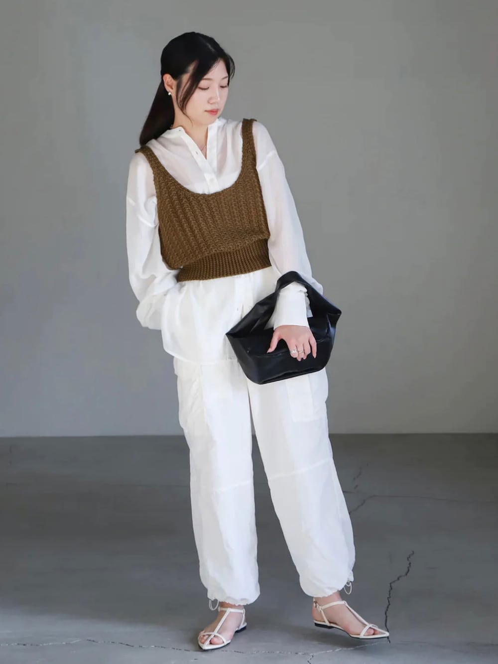 グリーン系のベスト、ホワイト系のシャツ/ブラウス、ホワイト系のカーゴパンツを着用したレディースの春コーディネートの2枚目の写真