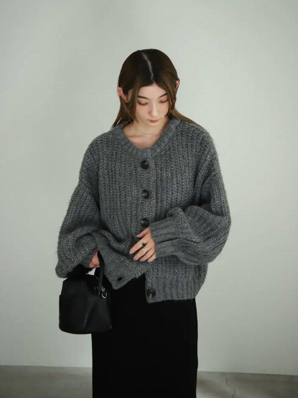 グレー系のカーディガン/ボレロ、ブラック系のスカート、ブラック系のスリッポンを着用したレディースの夏コーディネートの5枚目の写真