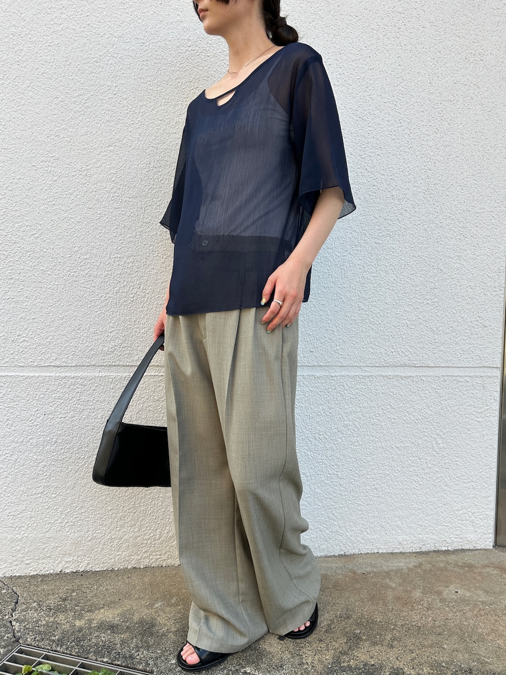 ブルー系のシャツ/ブラウス、グレー系のスラックス、ブラック系のショルダーバッグを着用したレディースの夏コーディネートの2枚目の写真