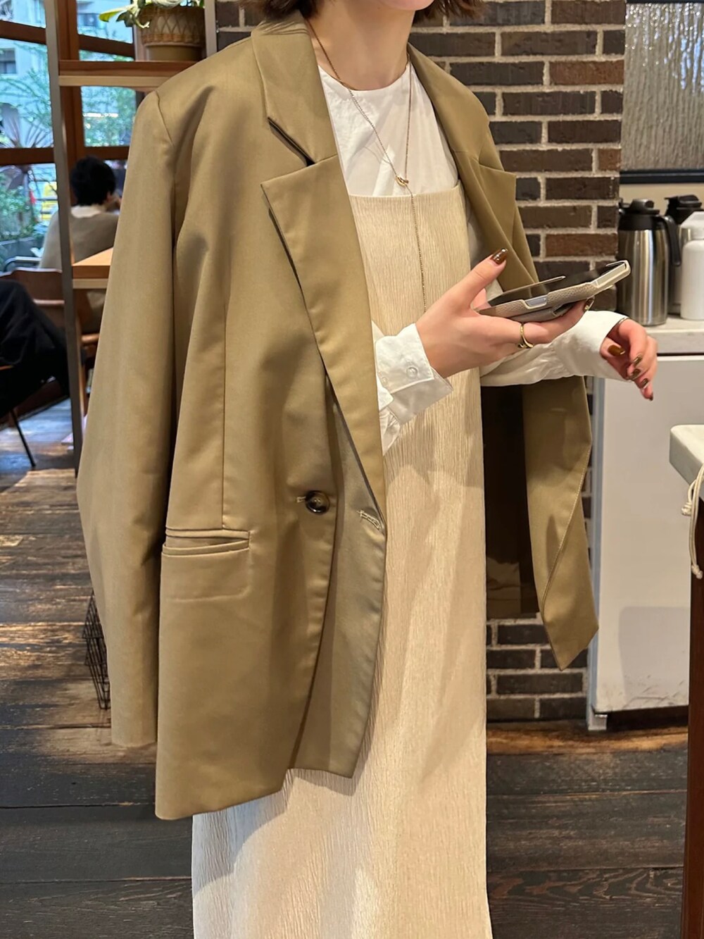 ホワイト系のワンピース、ホワイト系のシャツ/ブラウス、ベージュ系のテーラードジャケットを着用したレディースの冬コーディネートの4枚目の写真