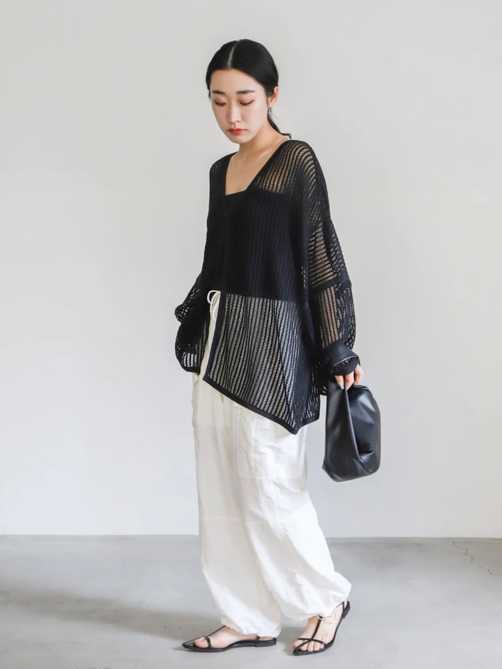 ブラック系のカーディガン/ボレロ、ブラック系のキャミソール、ホワイト系のカーゴパンツを着用したレディースの春コーディネートの3枚目の写真