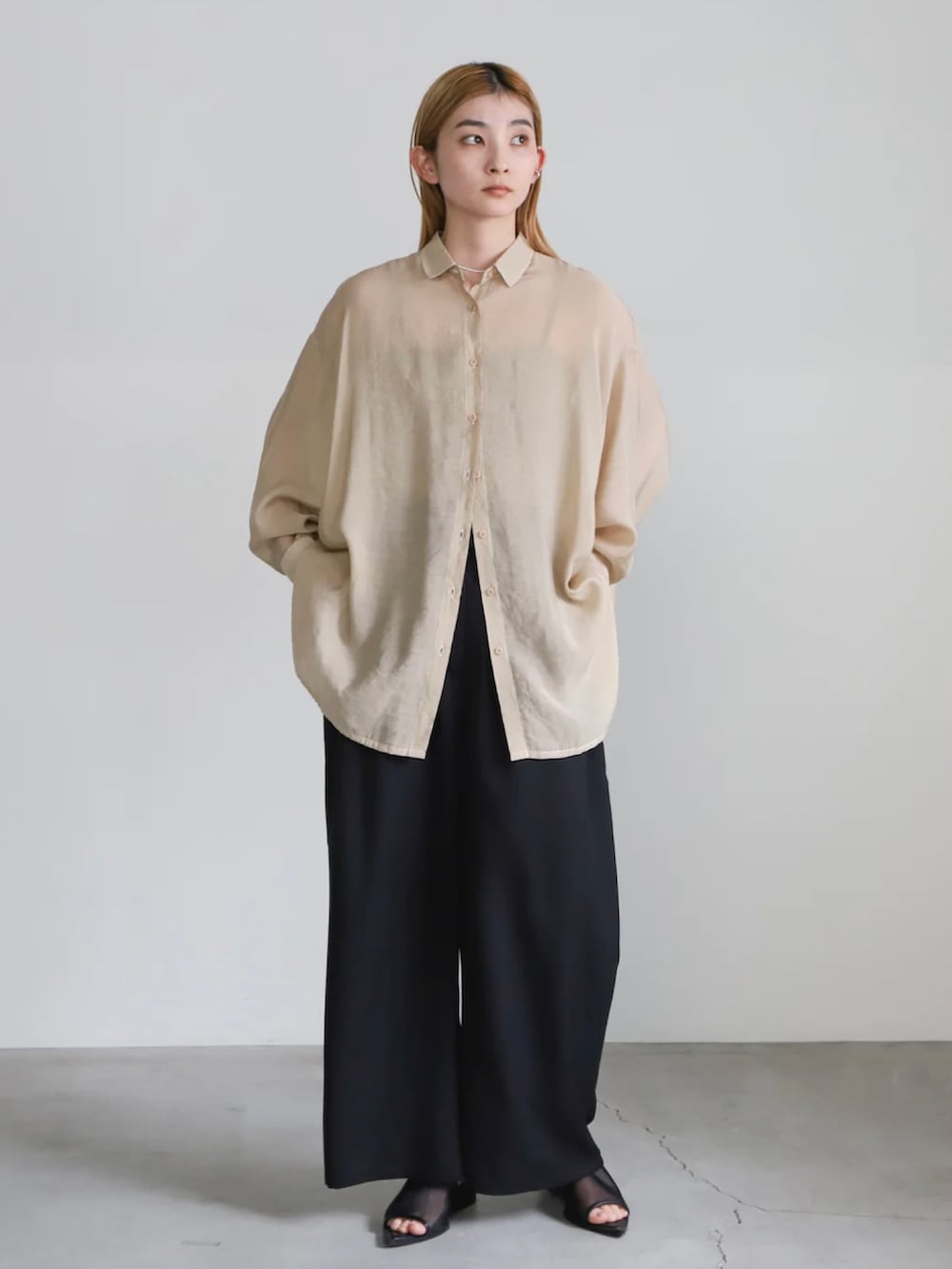 ベージュ系のシャツ/ブラウス、ベージュ系のキャミソール、ブラック系のスラックスを着用したレディースの冬コーディネートの2枚目の写真