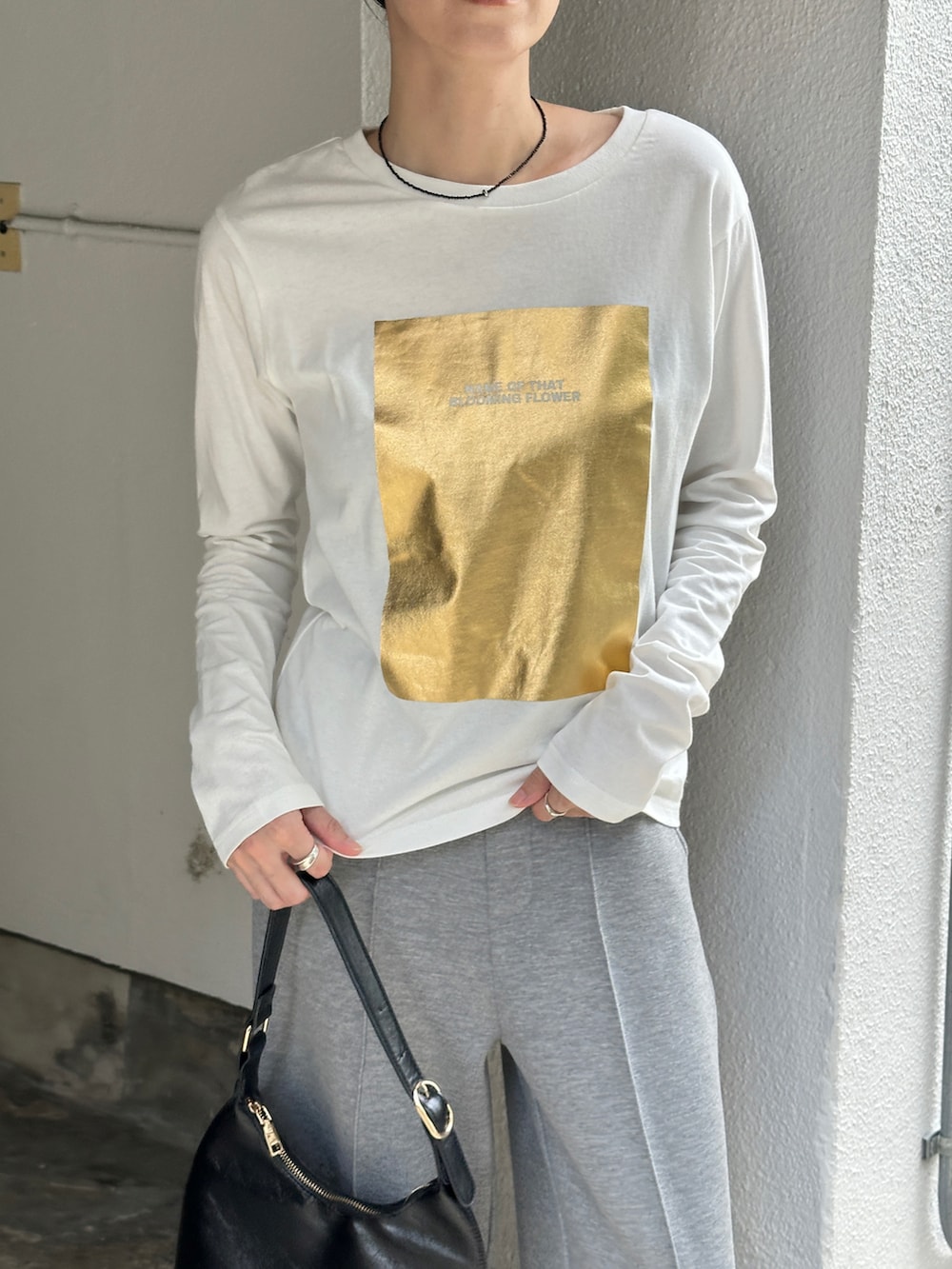 ホワイト系のTシャツ/カットソー、グレー系のその他パンツ、ブラック系のローファーを着用したレディースの秋コーディネートの4枚目の写真