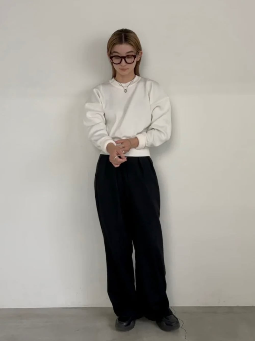 ホワイト系のニット/セーター、ブラック系のスラックスを着用したレディースの冬コーディネートの5枚目の写真