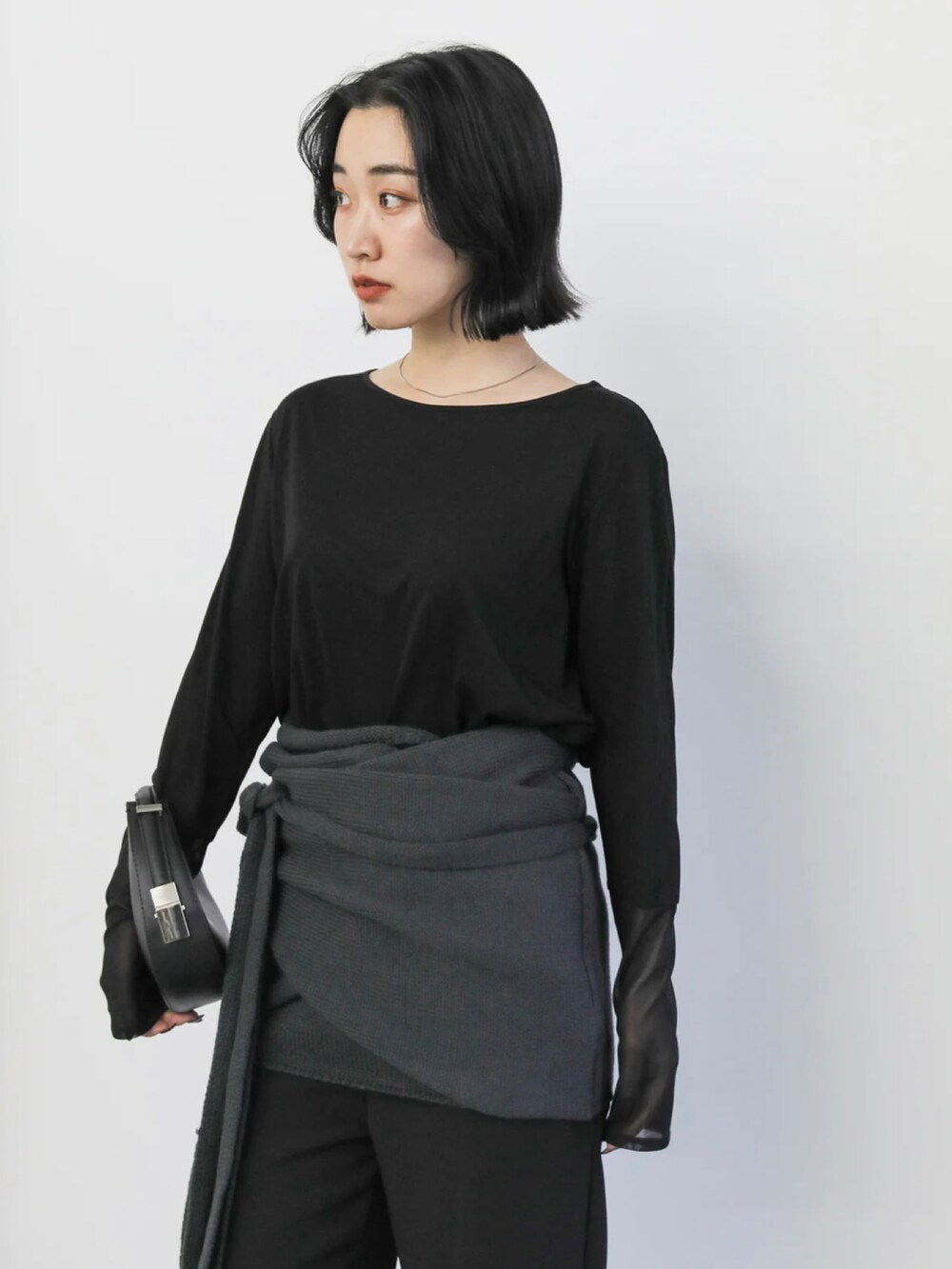 ブラック系のTシャツ/カットソー、ブラック系のハンドバッグ、ブラック系のサンダルを着用したレディースの冬コーディネートの4枚目の写真