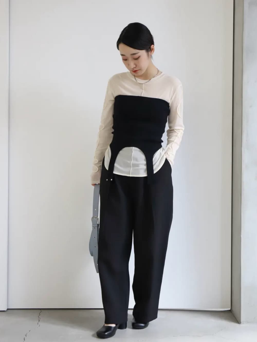 ホワイト系のTシャツ/カットソー、ブラック系のベスト、ブラック系のスラックスを着用したレディースの冬コーディネートの3枚目の写真