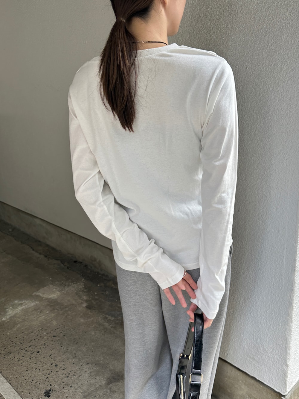 ホワイト系のTシャツ/カットソー、グレー系のその他パンツ、ブラック系のローファーを着用したレディースの秋コーディネートの5枚目の写真