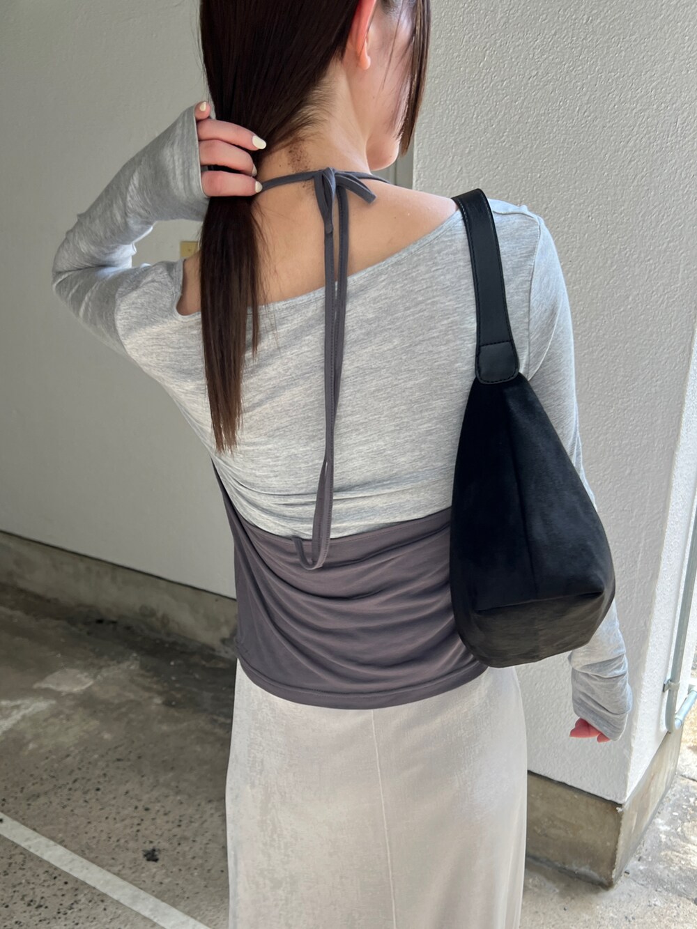 グレー系のTシャツ/カットソー、ホワイト系のスカート、ブラック系のショルダーバッグを着用したレディースの秋コーディネートの5枚目の写真