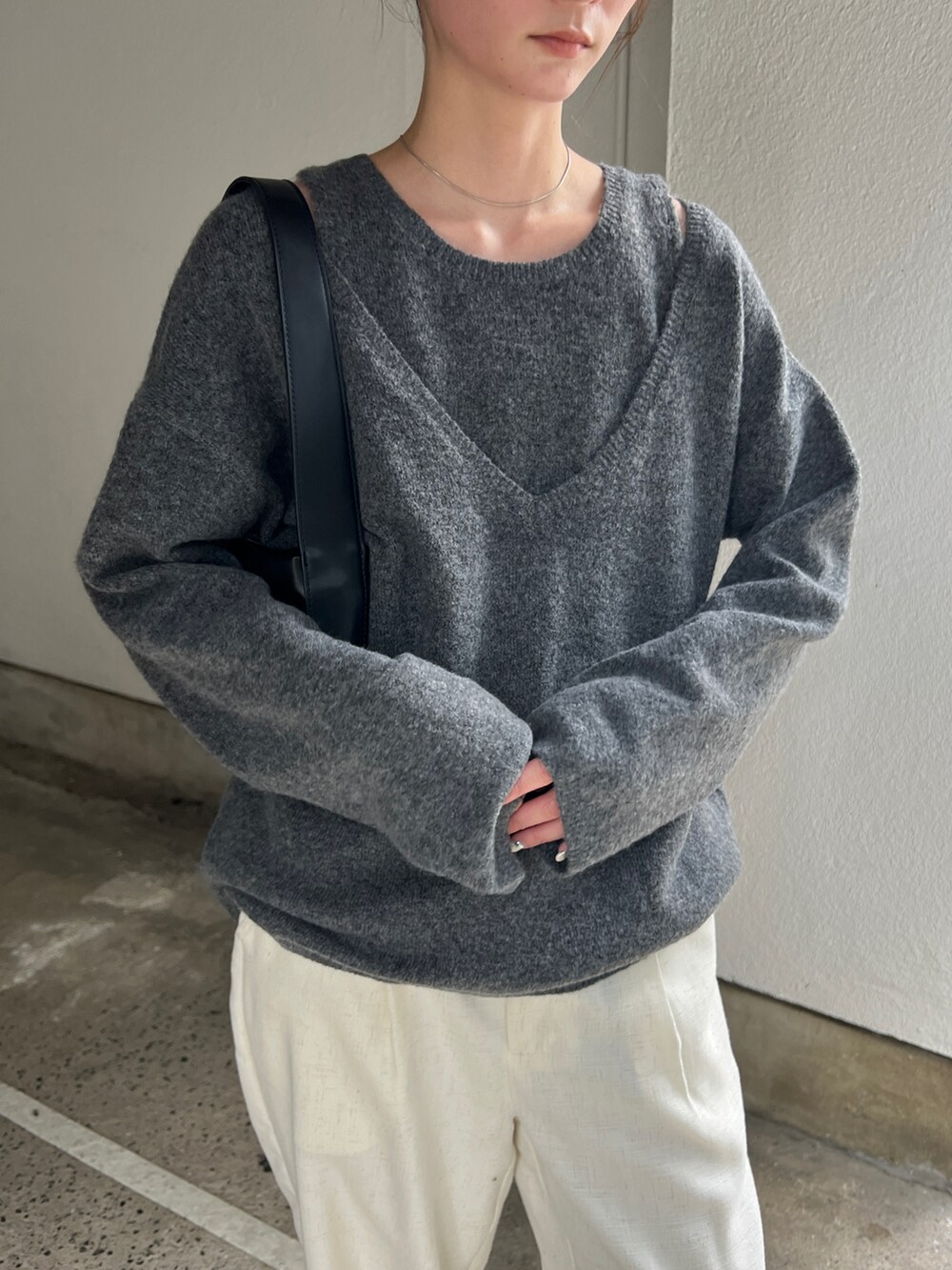 グレー系のニット/セーター、ベージュ系のスラックス、ブラック系のショルダーバッグを着用したレディースの秋コーディネートの4枚目の写真