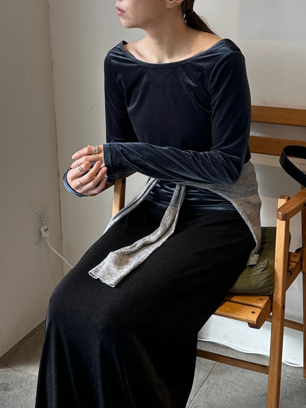 ブルー系のTシャツ/カットソー、グレー系のカーディガン/ボレロ、ブラック系のスカートを着用したレディースの冬コーディネートの3枚目の写真