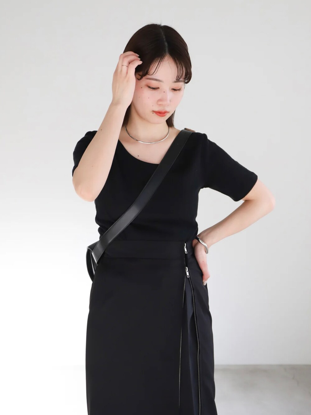 ブラック系のTシャツ/カットソー、ブラック系のスカート、ブラック系のスラックスを着用したレディースの春コーディネートの5枚目の写真