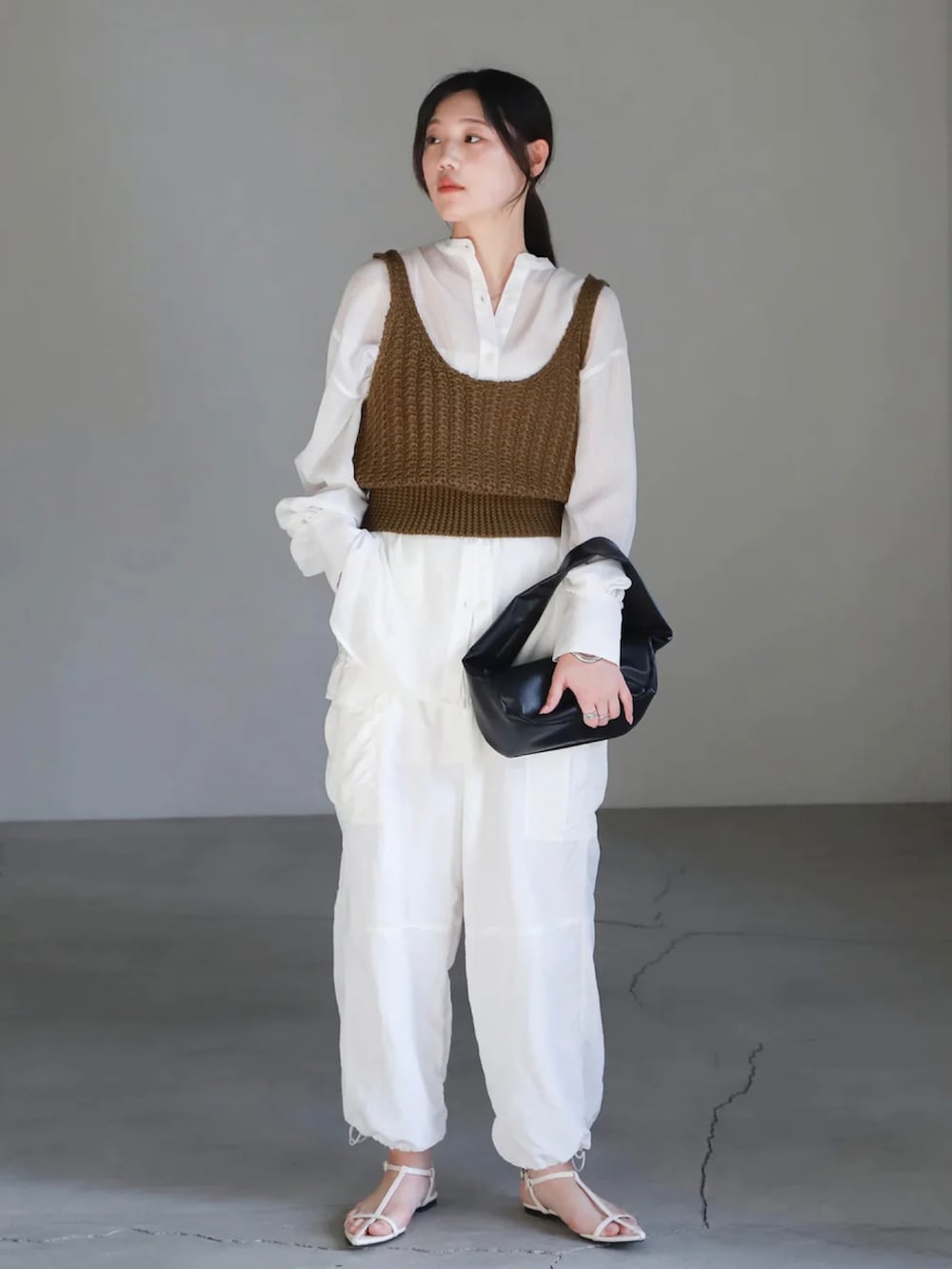 グリーン系のベスト、ホワイト系のシャツ/ブラウス、ホワイト系のカーゴパンツを着用したレディースの春コーディネートの3枚目の写真