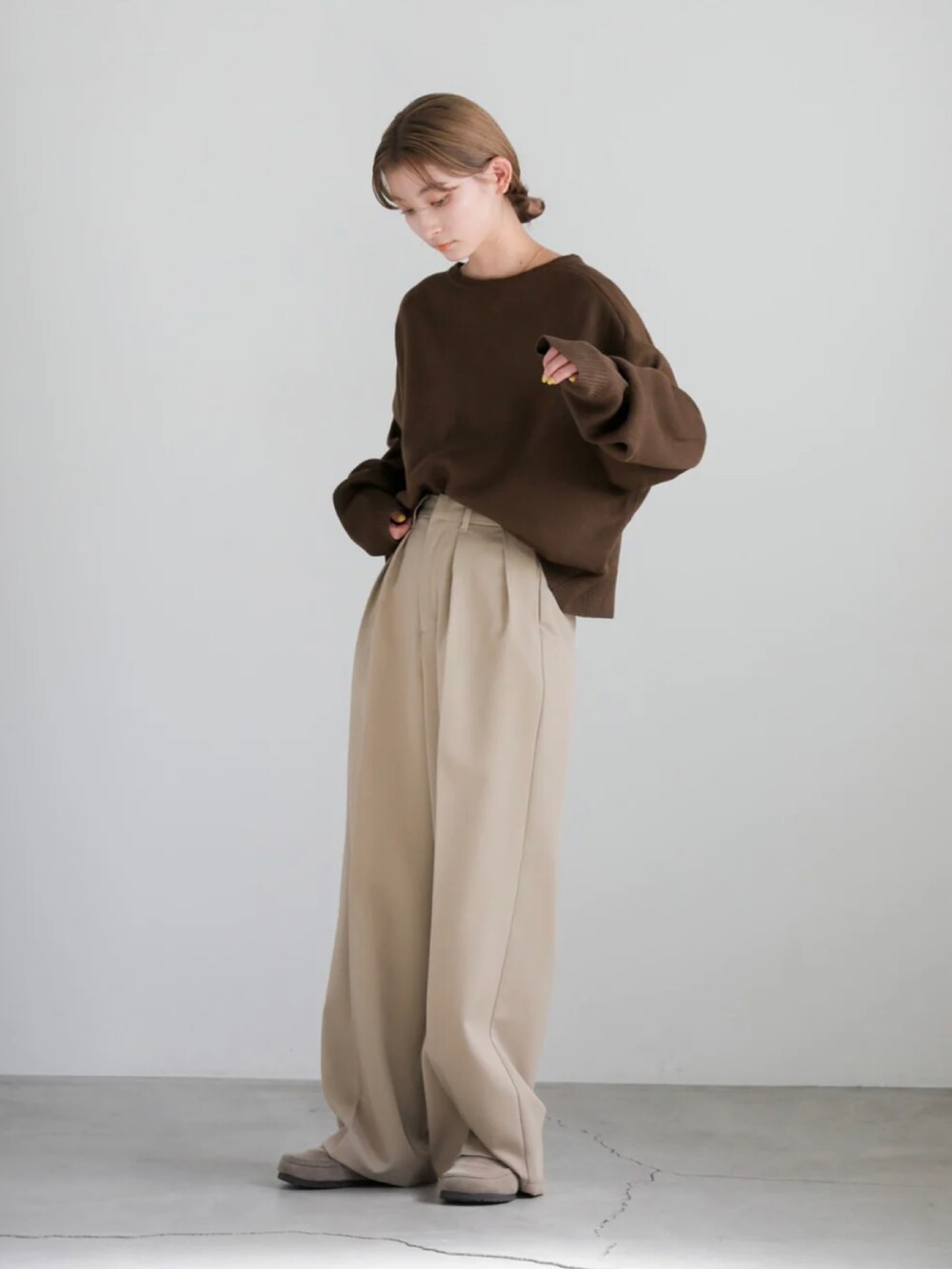 ブラック系のニット/セーター、ベージュ系のスラックスを着用したレディースの秋コーディネートの2枚目の写真