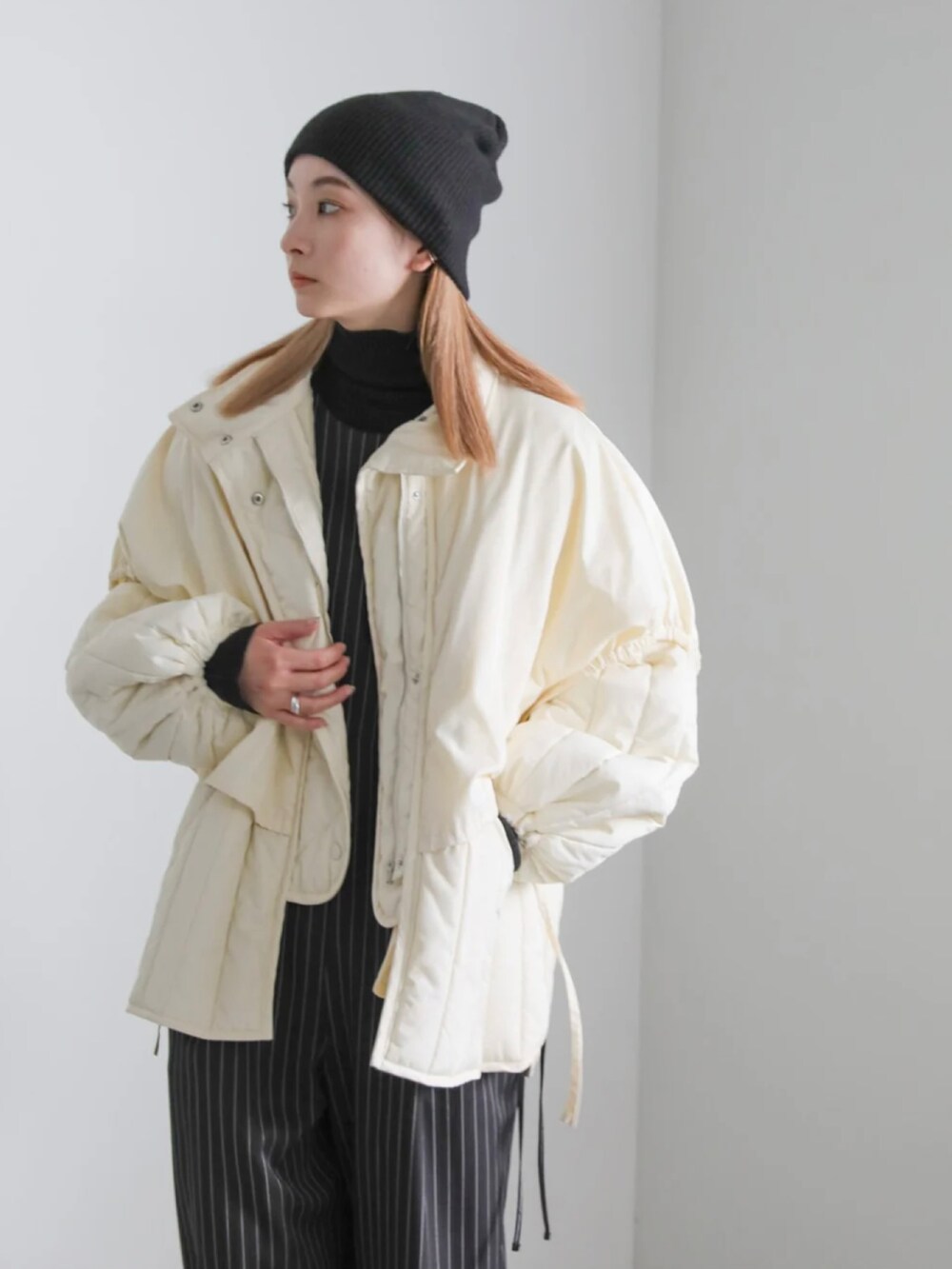 ホワイト系のダウンジャケット/コート、ブラック系のニットキャップ/ビーニーを着用したレディースの冬コーディネートの3枚目の写真