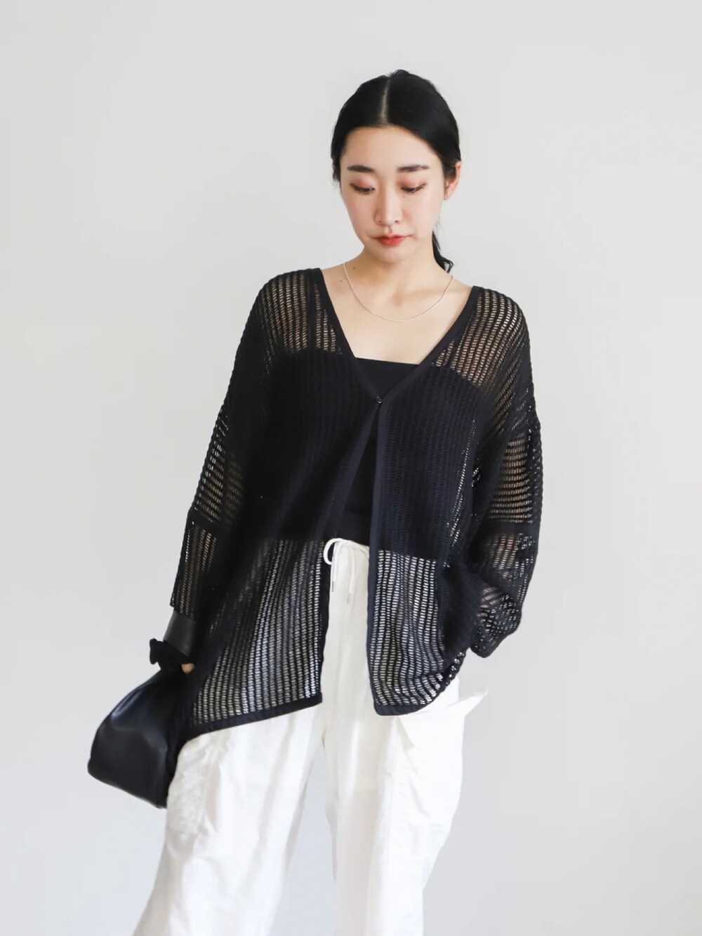 ブラック系のカーディガン/ボレロ、ブラック系のキャミソール、ホワイト系のカーゴパンツを着用したレディースの春コーディネートの4枚目の写真